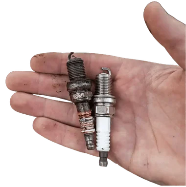 Mano sosteniendo bujías antiguas y nuevas